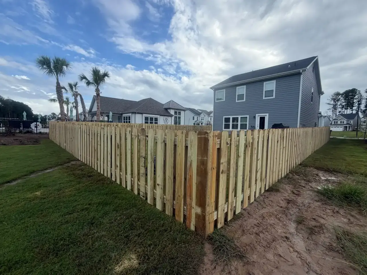 Wood picket fence defining the edge of a backyard