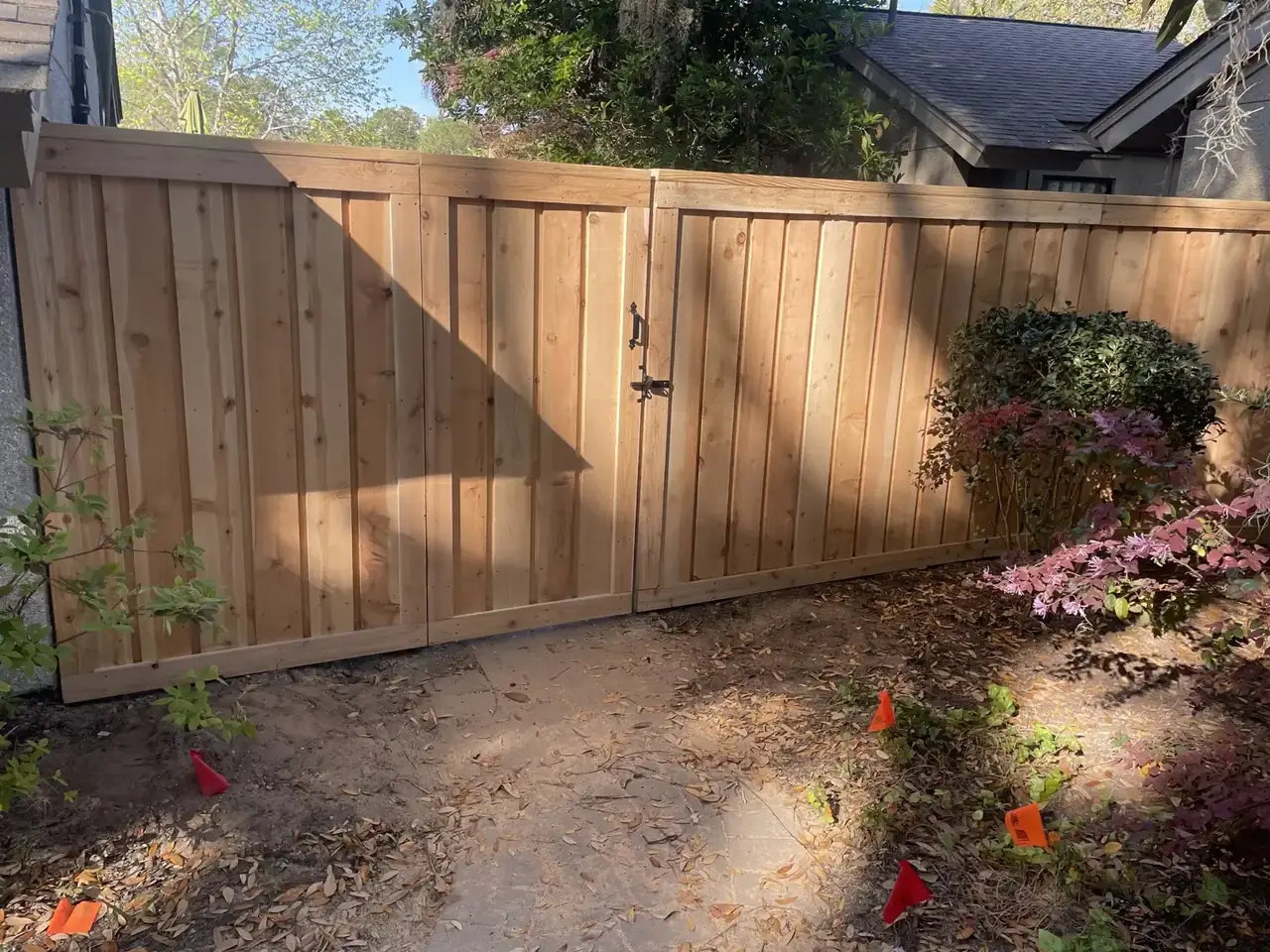 Wood gate and adjoining vertical privacy fence