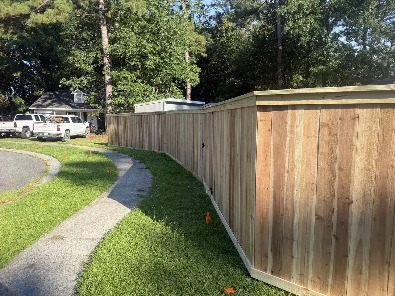 Cap and trim wood privacy fence with a finished top rail