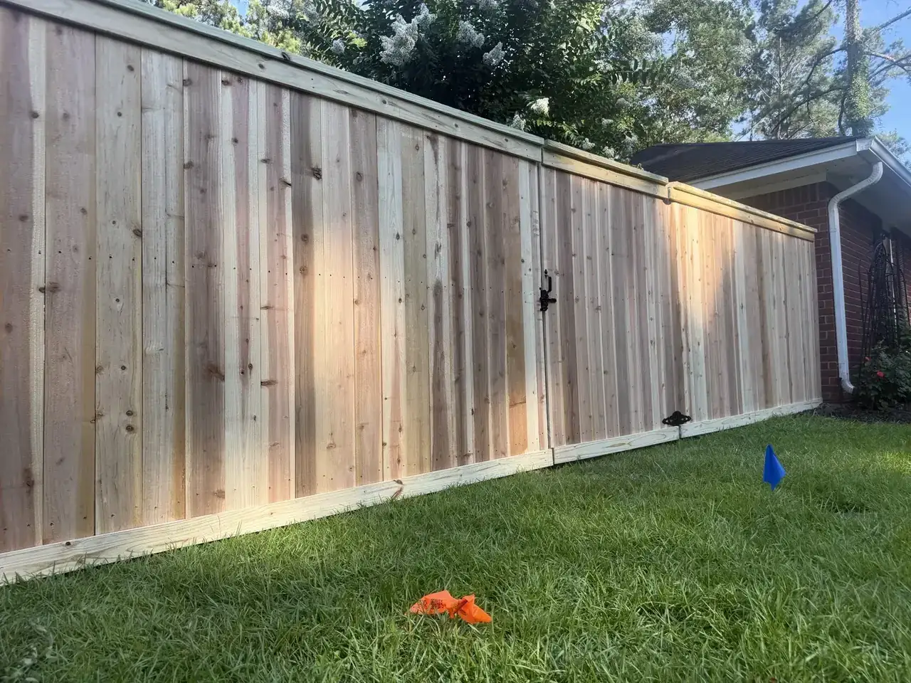 Vertical wood privacy fence along a green backyard